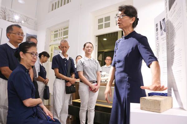 Volunteer Lai Shu Fan (seated) is moved to hear that the piece of brick displayed at the Gallery is symbolic of the unity of will of many people in building the Tzu Chi hospital. (Photo by Chua Teong Seng)